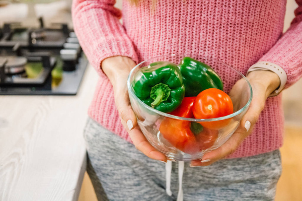 Hands washing fresh vegetables paprika red, green, yellow, in glass bowl - Фото, зображення