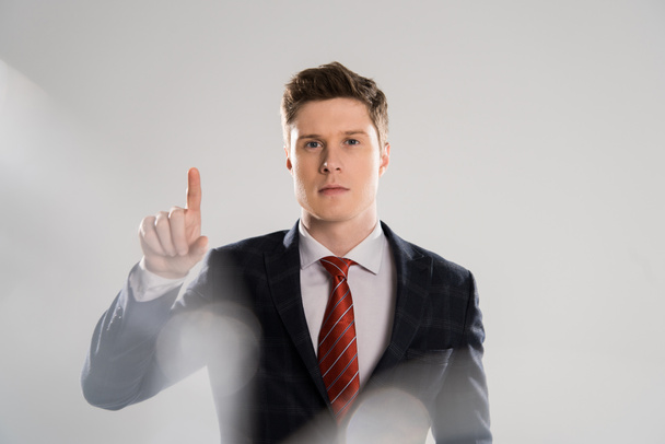 selective focus of young businessman pointing on grey - Foto, immagini