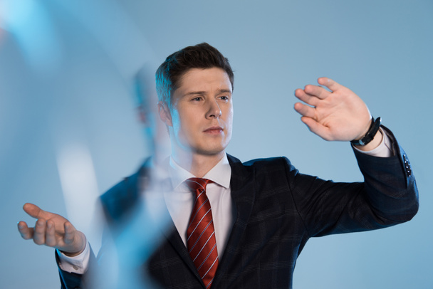 selective focus of professional businessman gesturing on blue - Photo, image