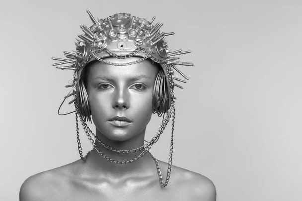 Futuristic woman in metal helmet with screws, nuts and chains - Fotó, kép