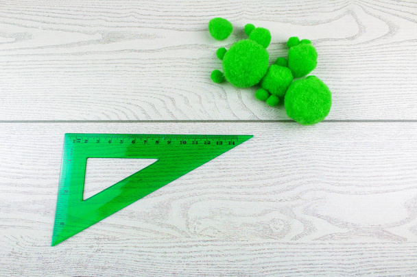 vista superior de bolas de fieltro verde y regla sobre fondo de madera blanca
 - Foto, Imagen