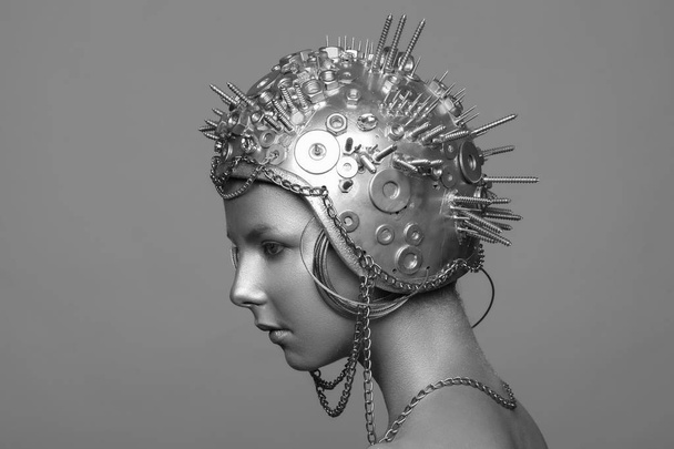 Futuristic woman in metal helmet with screws, nuts and chains - Фото, зображення
