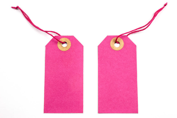 Roze papieren labels gebonden met snaren geïsoleerd op wit - Foto, afbeelding