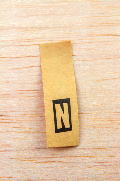 close-up shot of letter n on sticker attached on wooden surface - Photo, Image
