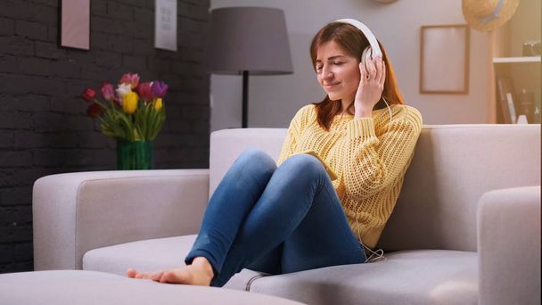 Portrait of happy woman at home is listens to music in headphones  - Φωτογραφία, εικόνα