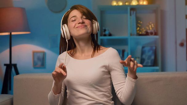 Portrait of happy woman at home is listens to music in headphones  - Foto, afbeelding