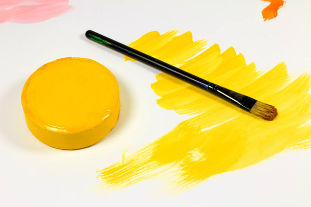 Kunst Studio verf. gele kleur en penseel geïsoleerd op wit - Foto, afbeelding