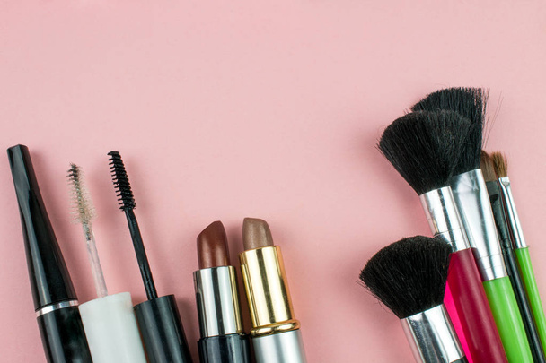 Косметика и инструменты для макияжа в розовом фоне
 - Фото, изображение