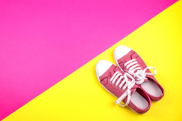 paar levendige sneakers op roze en gele achtergrond  - Foto, afbeelding