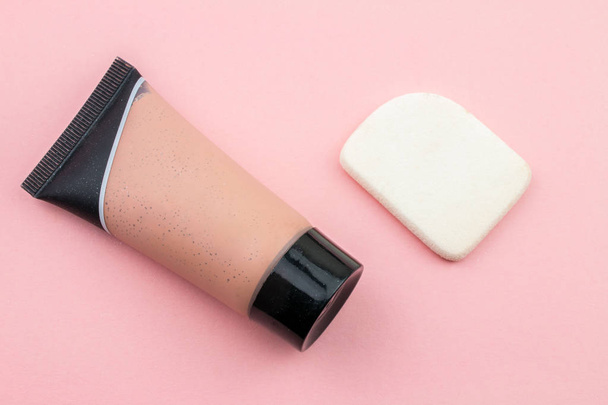 Láhev s tekutým make-upem s houbou na růžovém pozadí - Fotografie, Obrázek