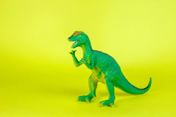 Juguete de plástico dinosaurio en fondo amarillo
. - Foto, imagen