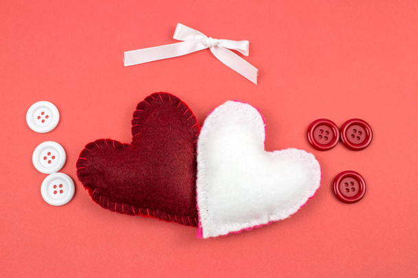 vue du haut des cœurs en feutre avec ruban et boutons sur fond rouge
  - Photo, image