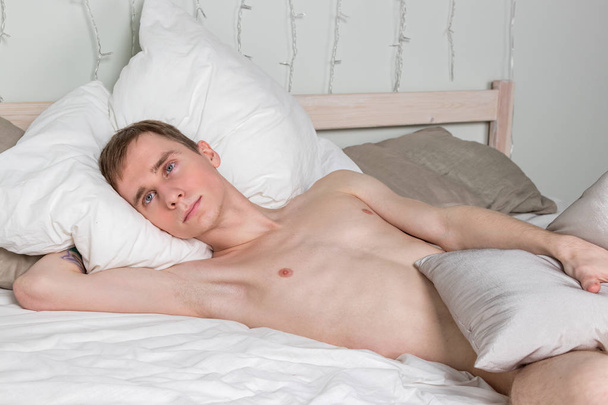 Handsome young adult man sleeping in bed. Sexy naked guy is resting - Fotoğraf, Görsel