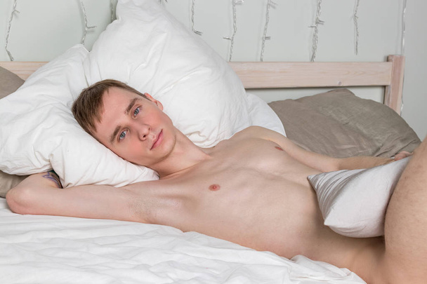 Handsome young adult man sleeping in bed. Sexy naked guy is resting - Φωτογραφία, εικόνα