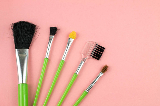 Brosses et outils cosmétiques de maquillage en fond rose
 - Photo, image
