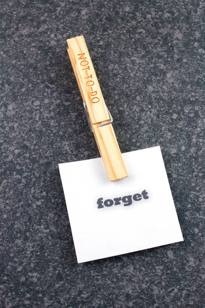 top view of wooden not to-do clothespin with forget note on dark background  - Photo, Image