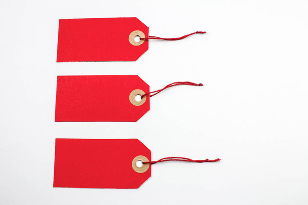 Ετικέτες κόκκινο χαρτί δεμένο με συμβολοσειρές που απομονώνονται σε λευκό - Φωτογραφία, εικόνα