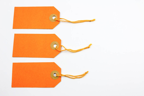 cartellini di carta arancione legati con stringhe isolate su bianco
 - Foto, immagini