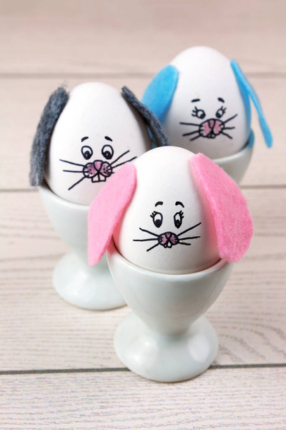 Conejitos de Pascua con orejas de fieltro en huevos blancos
 - Foto, Imagen