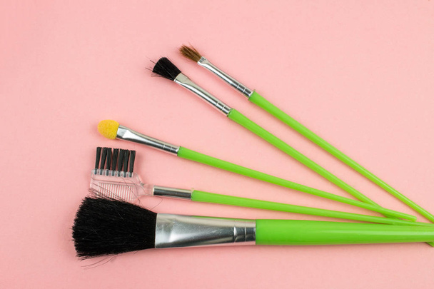 Косметические кисти и инструменты макияжа на розовом фоне
 - Фото, изображение