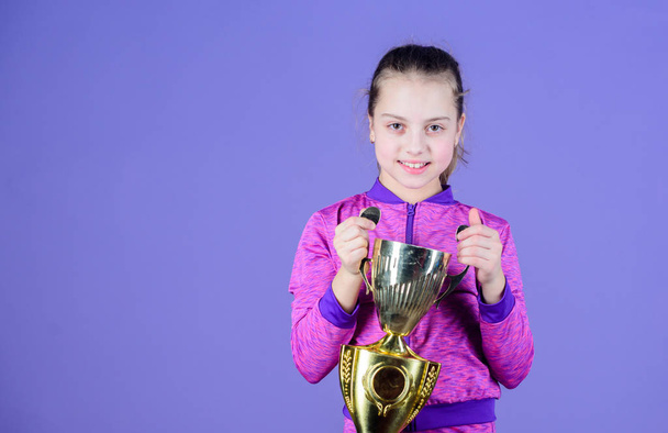 She is the best. Small girl holding silver cup. Little child with cup shaped sports trophy. Cute athlete being awarded with cup. Adorable cup winner, copy space - Foto, Bild