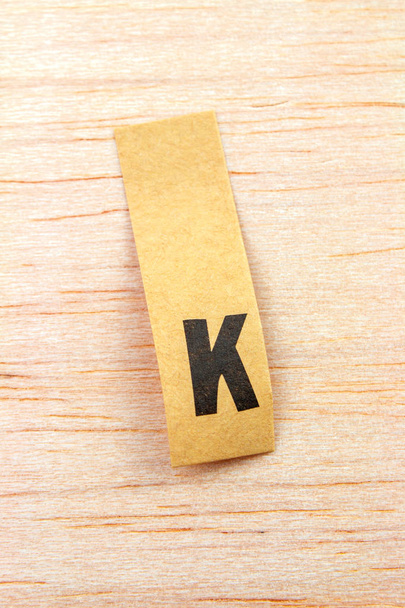 close-up shot of letter k on sticker attached on wooden surface - Fotografie, Obrázek