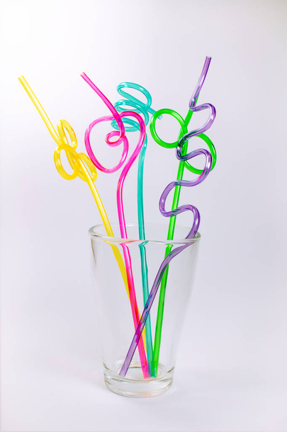 Цветные пластиковые соломинки в стекле на белом фоне
 - Фото, изображение