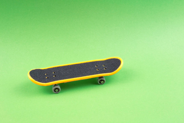 Mini Skateboard Toy sobre fondo verde
 - Foto, Imagen