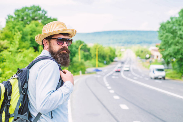 Man at edge of highway wait transport. Travel alone. Hitchhiking means transportation gained asking strangers for ride in their car. Hitchhiker travel alone try stop transport to get to destination - 写真・画像