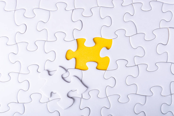 White jigsaw puzzle and missing pieces with selective focus and crop fragment - Photo, Image