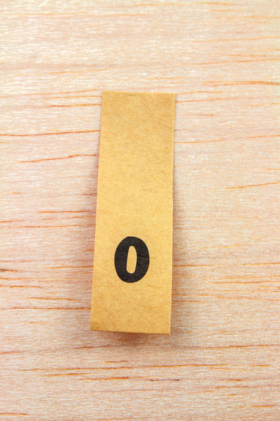 close-up van letter o op sticker op houten ondergrond - Foto, afbeelding
