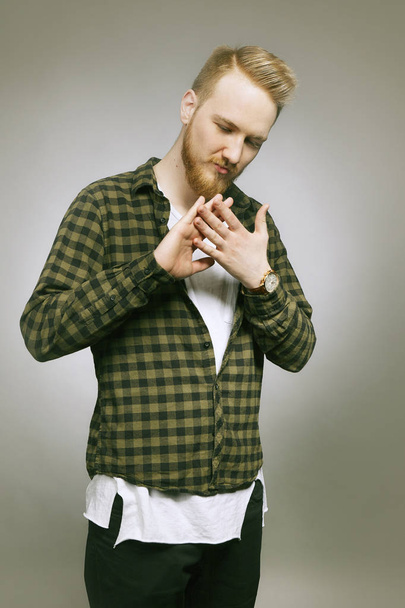 Young musician in chequered shirt posing in studio - Fotografie, Obrázek