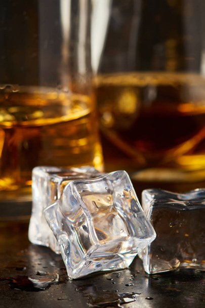 Ledové kostky s sklenici whisky za na černém pozadí rustikální - Fotografie, Obrázek