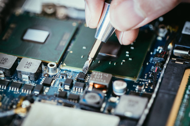 Technician is fixing a computer circuit board, hand and screwdri - Photo, Image