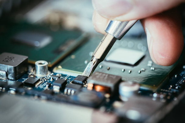 Technician is fixing a computer circuit board, hand and screwdri - Valokuva, kuva