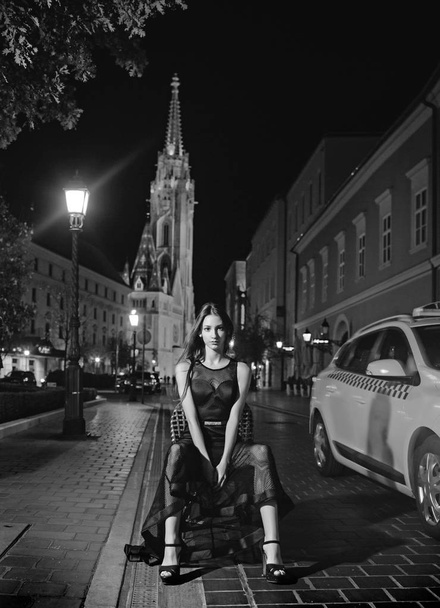 Luxury woman in evening dress at night city go to prom on taxi. Girl with glamour makeup. Night city with princess in celebrity style. Fashion and beauty of business lady. Sexy girl in elegant dress - Fotoğraf, Görsel
