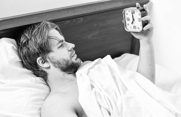 Imagen que muestra a un joven estirándose en la cama. Un hombre guapo bostezando y estirando los brazos. Hombres en la cama
. - Foto, Imagen