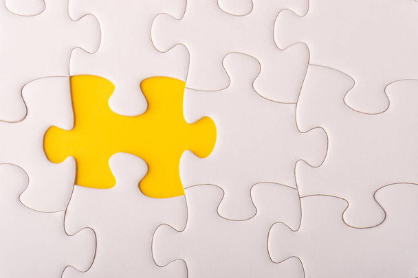 White jigsaw puzzle and missing pieces with selective focus and crop fragment - Photo, Image