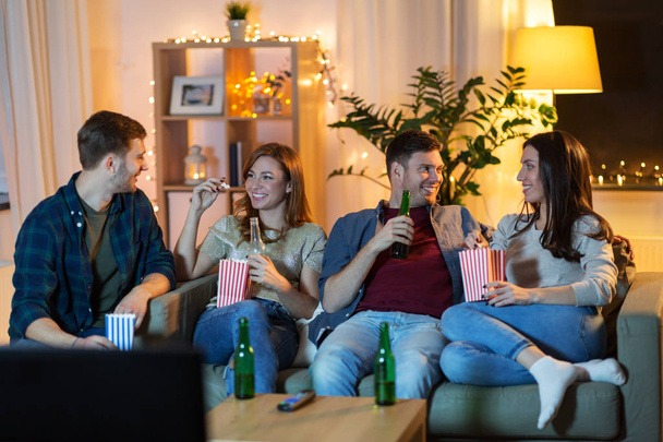 friends with beer and popcorn watching tv at home - 写真・画像