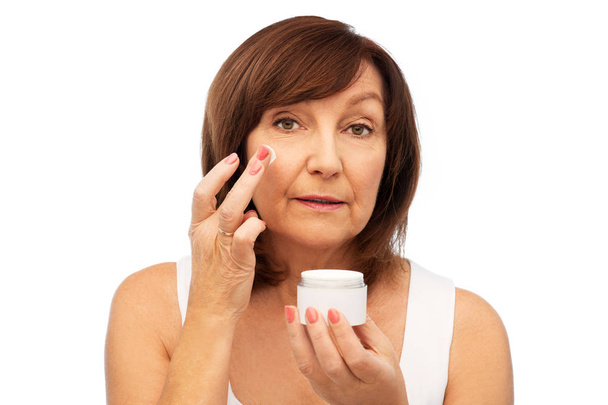 senior woman applying cream to her face - Фото, зображення