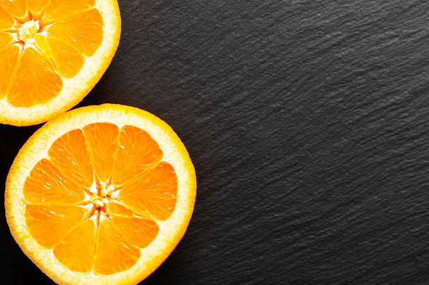 Τροφίμων έννοια οργανικών πορτοκάλι ή γκρέιπ-φρουτ φρούτα κομμένα haft σε μαύρο sl - Φωτογραφία, εικόνα