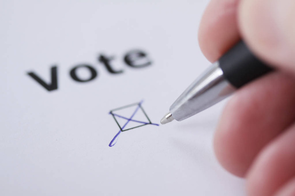 Ψηφοφορία - το χέρι του ανθρώπου ορίζει σημάδι στο πλαίσιο ελέγχου με στυλό - χεριών, το word και το στυλό θολή - Φωτογραφία, εικόνα