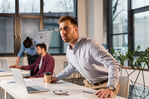 strach podnikatel drží pohárek u kolegy v kanceláři - Fotografie, Obrázek