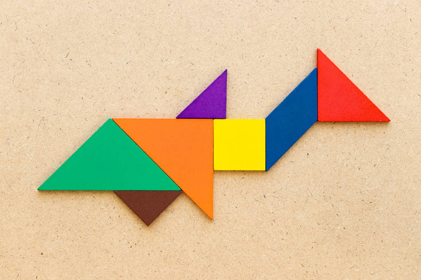 Puzzle couleur tangram en forme de requin ou de baleine sur fond bois - Photo, image