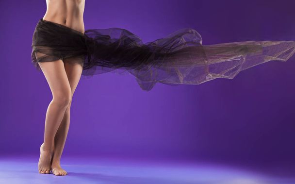 beautiful female body with black fabric loop on a purple - Foto, Imagem