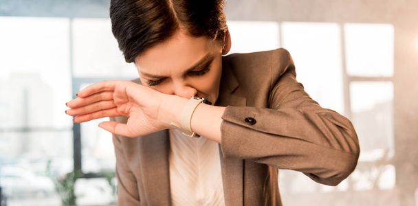 attractive scared woman covering nose in office with smoke - Foto, Bild