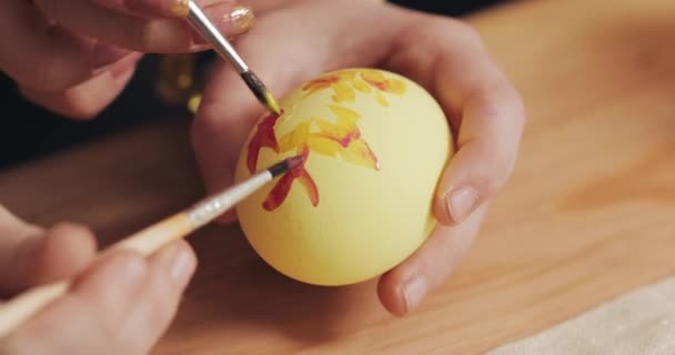 Close up of mother and daughter hands coloring easter eggs with colors and brush. Colorful easter eggs. Preparation of the Easter - 映像、動画
