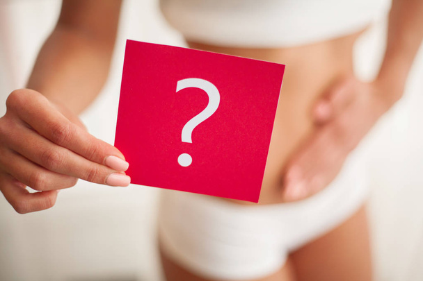 La santé. Corps de femme en sous-vêtements avec carte de question près du ventre
 - Photo, image