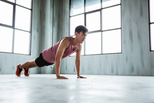 fitness man doing push ups in gym indoor - Foto, afbeelding