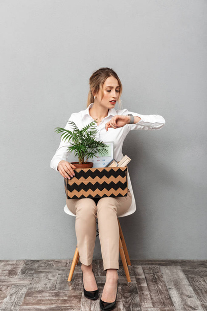 Portrait of attractive woman holding box with office belongings  - Foto, Imagen
